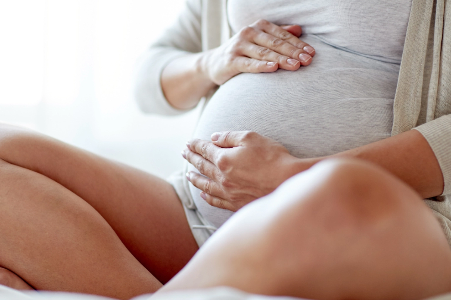 Pregnant woman hands holding belly
